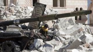 A Syrian boy plays on a destroyed tank near a destroyed mosque in Azaz, northern Syria. Photo: 23 September 2012