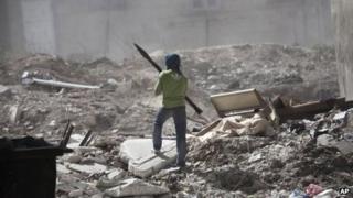 A Free Syrian Army fighter holds a rocket-propelled grenade launcher while taking cover after a tank blast in Aleppo, Syria, Wednesday, Sept. 26, 2012