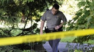 State Trooper Matt Losh emerges from the backyard of a home on Meeting House Hill Circle in New Fairfield, Connecticut, where a fatal shooting took place