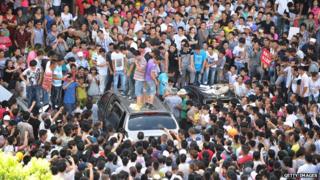 На этом снимке, сделанном 28 июля 2012 года, тысячи людей протестуют в местных правительственных учреждениях в Кидонге, провинция Цзянсу на востоке Китая