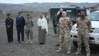 Mourners look on as the body of 28-year old Lt. Tim O'Donnell of the Royal New Zealand Infantry Regiment prepares to leave Bamiyan airport