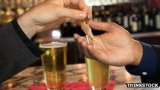 Hands handing over car keys in a pub