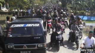 Residents carrying wooden sticks on motorcycles during clashes in Lampung, 29 October 2012