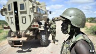 A Ugandan soldier in Somalia watches a convoy depart