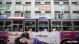 Passengers wait for a bus to leave a station in front of a shopping mall in central Yangon
