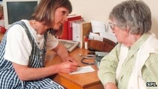 GP taking notes with a patient