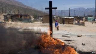 Tyres burn after being set alight and placed on a road sign north of Cape Town during a farm workers strike - 14 November 2012