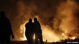 Palestinians try to extinguish fire following an Israeli air strike on November 14