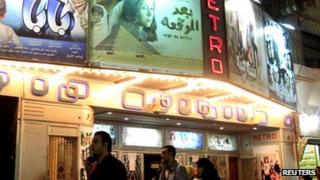 People walk past a poster of the movie outside a cinema in Cairo