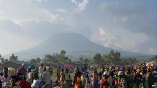 People at a roadside on the outskirts of Goma with the Nyiragongo volcano on the horizon - eastern DR Congo, 3 August 2012