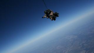 Ray Woodcock skydiving with a view of the Earth