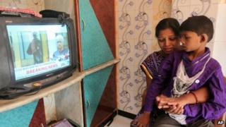 Karuna, wife of a victim of the 2008 Mumbai attacks Thakur Budha Vaghela, breaks down as she watches with her son Neeraj the news of Mohammed Ajmal Kasab"s execution, in Mumbai, India, Wednesday, Nov. 21
