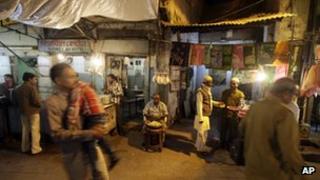 People walk past stalls at the entrance to Nizamuddin Dargah, a complex of tombs, mosques and stalls centered on the burial site of revered Sufi saint Nizamuddin Auliya, in New Delhi, India, Tuesday, Nov. 20, 2012.