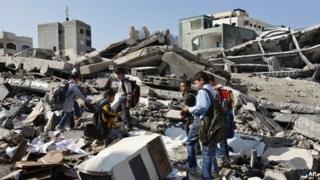 Palestinian school children walk in the rubble left days after an Israeli strike destroyed the Hamas interior ministry in Gaza City