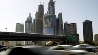 Автомобили проезжают мимо фотографии премьер-министра и президента ОАЭ в Internet City в Дубае (файл)