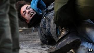 Greek riot police detain a protester in Thessaloniki, 6 December