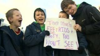 Children hold a placard protesting against council pitch fees