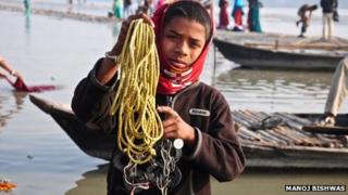 Rohit Kumar, 10, holding up his magnet rings tied to a yellow plastic rope