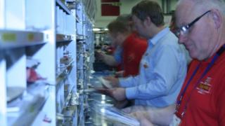 Posties sorting mail