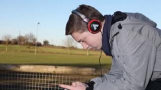 Plentyn yn gwisgo clustffonau