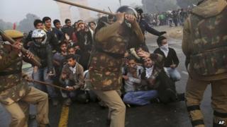 Протестующие защищают себя, когда индийская полиция готовится избить их палками во время жестокой демонстрации возле Ворот Индии против группового изнасилования и жестокого избиения 23-летнего студента в автобусе на прошлой неделе, в Нью-Дели, Индия, воскресенье, декабрь . 23, 2012.