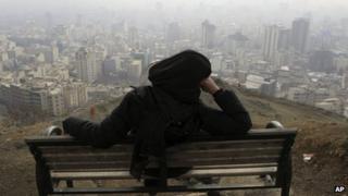 Iranian woman looks on at the smog covering Tehran, Iran, on 4/1/13