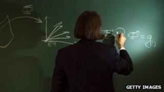 Mathematician writes out formula on a blackboard
