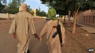 Two young fighters of the Islamist group Movement for Oneness and Jihad in West Africa (MUJAO) walk in the streets of Gao on July 17