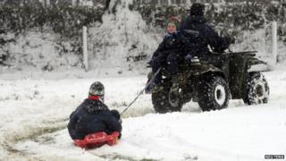 Boy rides toboggan in snow