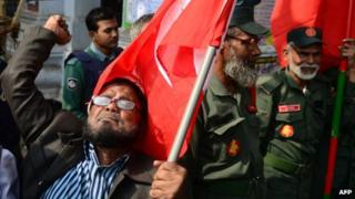 Активист выкрикивает лозунги, когда он и другие, в том числе бывшие борцы за свободу, которые воевали против Пакистана во время войны 1971 года, проводят демонстрацию у здания Международного трибунала по уголовным делам в Дакке 21 января 2013 года.