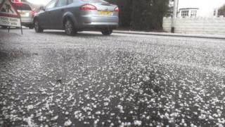 Cenllysg ar un o ffyrdd Caerdydd wedi'r eira, y gwynt a'r glaw
