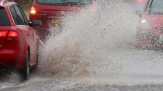 Cars drive through flood water
