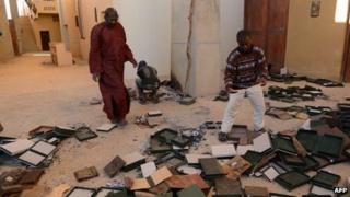 Men recover burnt ancient manuscripts at the Ahmed Baba Centre