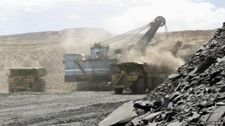 Гидравлическая лопата загружает грузовик на алмазный рудник в Ботсване