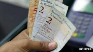 Cashier counts bolivar notes in Venezuela