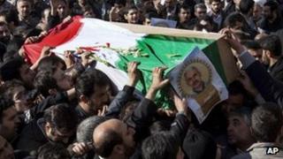 Iranian mourners carry the flag draped coffin of Gen Hassan Shateri, in Tehran, Iran