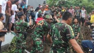 Rescuers search for the victims of a landslide in Manado, North Sulawesi, Indonesia, 17 February 2013