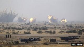 Army soldiers watch as target is being destroyed during the Indian Air Force (IAF) fire power demonstration exercise "Iron Fist 2013" in Pokhran, Rajasthan February 22, 2013.