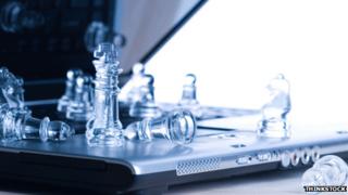 Стеклянные шахматные фигуры на ноутбуке
