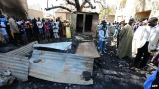 People look at the scene of the fire at a Koranic school in Dakar, Senegal (4 March 2013)
