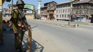 An Indian paramilitary trooper keeps watch during a curfew in Srinagar on March 6, 2013
