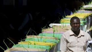 An unidentified man walks past stacked ballot boxes waiting to have their votes tallied, at a vote tallying centre in Nairobi, Kenya - Tuesday 5 March 2013