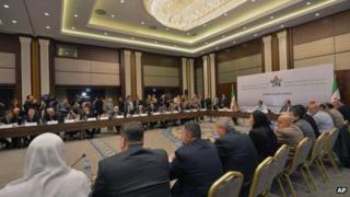 Head of the new Syrian National Coalition for Opposition and Revolutionary Forces Mouaz al-Khatib, rear-center, speaks during a meeting in Istanbul