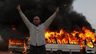 An anti-Morsi protester celebrates after Muslim Brotherhood buses were set on fire in Cairo. Photo: 22 March 2013