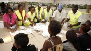 Poll officials count ballots at the polling centre of Kisumu Sports Ground, western Kenya, following Monday's general elections