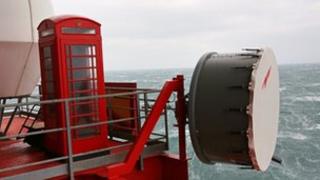 An old red phone box bolted to the deck of the platform