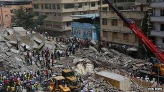 Rescuers search for survivors amongst the rubble of a collapsed building in the Kariakoo district of central Dar es Salaam (29 March 2013)