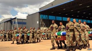 South African troops carry coffins of fallen colleagues at air force base near Pretoria - 28 March