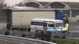 One of the vans targeted in the robbery in Italy and the lorry the robbers used to block the road