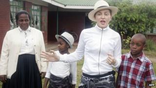 Madonna with her children and Yasinta Chapomba, Executive Director of Mphandula Childcare Centre, in Namitete, Malawi, on 5 April 2013